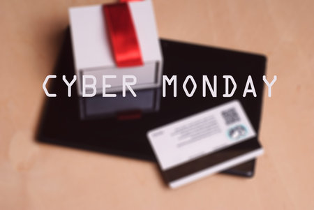 Background image, defocus, Credit card and electronic tablet on wooden table, gift with red ribbon,...