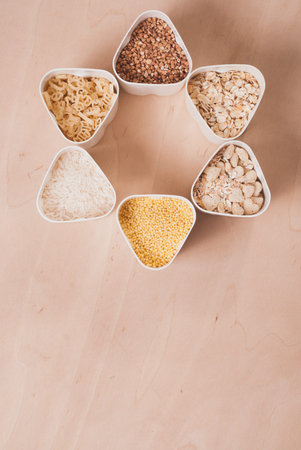Collection of cereals, grains: rice, oats, buckwheat, millet, wooden table, country kitchen, white...