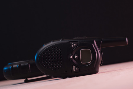 portable radio on a wooden table, a walkie-talkie radio, wood texture, devices to send radio signals, on a black backgroundの写真素材