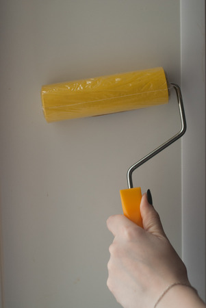 hand with yellow paint rollers, feminine touch,の写真素材