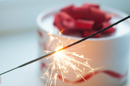 The gift on the table, Sparkler, white box with a red ribbon,