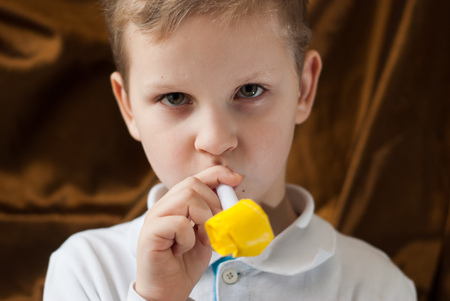 A little boy with a yellow squeaky toy, a cute playful child in a white shirtの写真素材