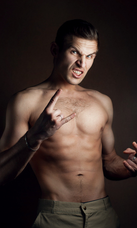 Aggressive young man posing, Studio portrait, man screaming, bare-chested, brutal man,の写真素材