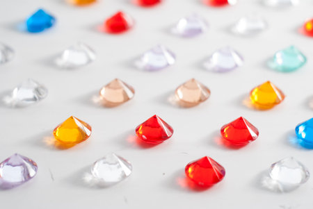 A collection of different faceted stones on a white background, pattern of multicolored precious jewelryの写真素材
