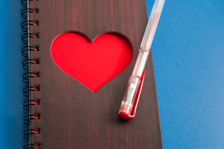 A notebook with a large red heart on a blue background, gel pen, top view, Valentineの写真素材