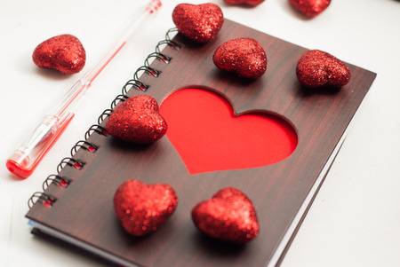 Notepad on white background, large Valentine decorative heartsの写真素材