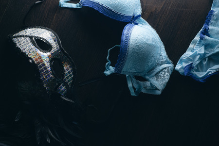 Sex after the party, quick sex concept, scattered with lingerie in the bedroom, the mask on the wooden floorの写真素材