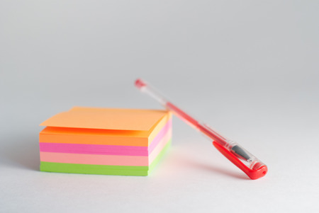 adhesive sticker, Notepad for reminders, red gel pen, office supplies on a light backgroundの写真素材