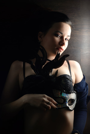 sexy woman with mask, lying on a wooden floor, a gentle and sensual girl with beautiful bodyの写真素材