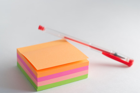 adhesive sticker, Notepad for reminders, red gel pen, office supplies on a light backgroundの写真素材