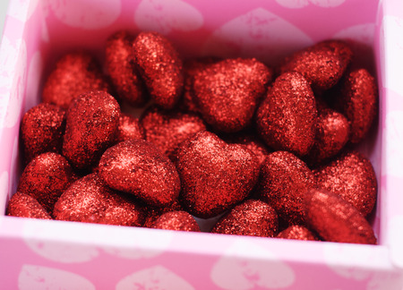 Red decorative hearts in a pink box made of cardboard,の写真素材