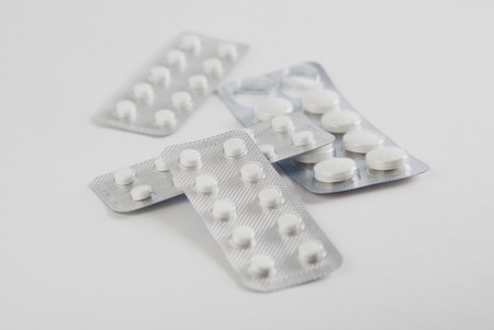 A bunch of blister packs of pills on white background, medicine, concept of healthの写真素材