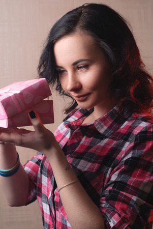Sexy model girl opens the gift, plaid shirt, happy woman, women's day, the brunette ladyの写真素材