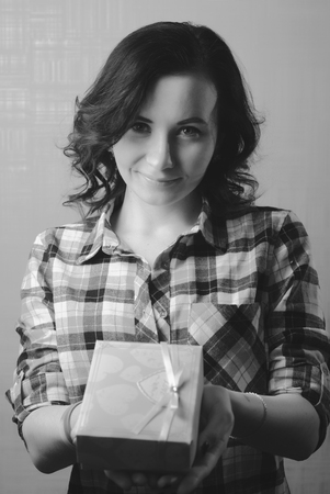 Sexy model girl holds box with gift, plaid shirt, happy woman, women's day, the brunette ladyの写真素材