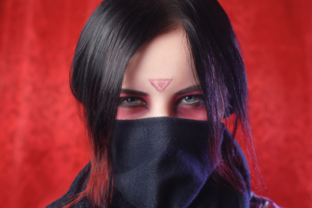 the girl with the covered face on a red background, fantasy creative makeup, fancy fairy image, woman portrait closeupの写真素材