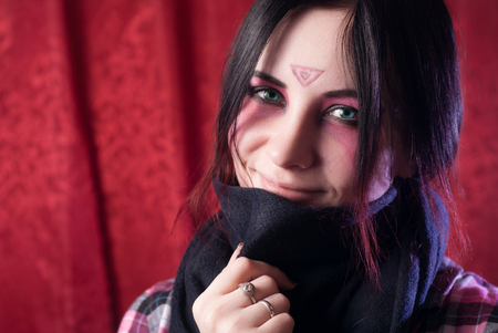 the girl with the covered face on a red background, fantasy creative makeup, fancy fairy image, woman portrait closeupの写真素材