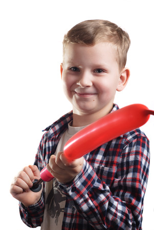 little boy inflates the balloon, isolated on white background, happy childhood, a young boy in a plaid shirt, baby closeup portraitの写真素材