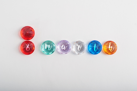 The inscription March 8, faceted colored stones on a white background, international women's day, template for postcardの写真素材