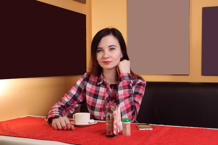Sweet brunette girl drinking coffee in the morning in a cafe, templates for painting on the backgroundの写真素材