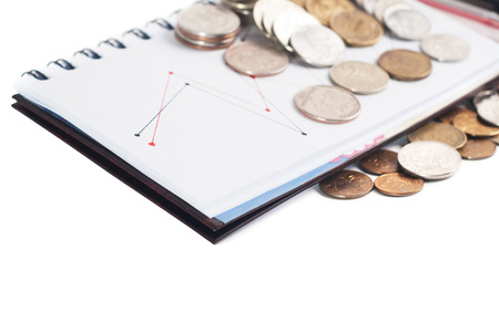Closeup stack of coins, pen and notepad on white background. Business concept.の写真素材