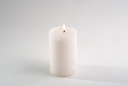 the white candle on white background, burning candle,の写真素材