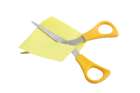 Scissors with yellow handles, scissors cut the yellow sheetの写真素材