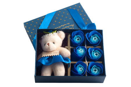The gift in the blue box with lid, isolated on a white background, a small Teddy bear, buds of blue rosesの写真素材