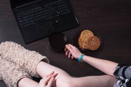 A female blogger. coffee in front of laptop, sitting on the floor, body partsの写真素材