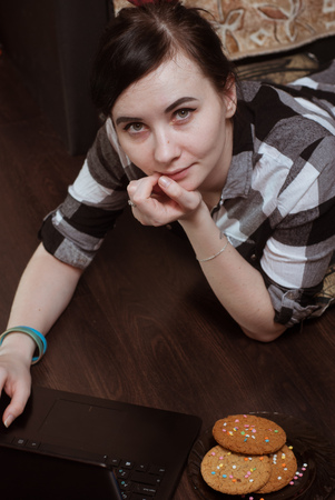 Cute girl working on laptop at home, brunette in black glassesの写真素材