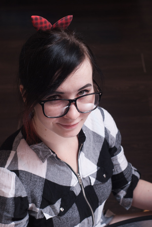 Portrait of beautiful girl in black glasses, brunette in a plaid dress, girl hipsterの写真素材