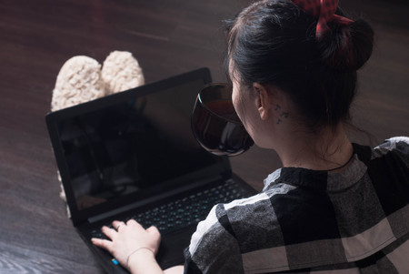 A young female blogger, working at home, brunette is typing, laptop on my kneesの写真素材