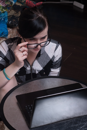 Cute girl working on laptop at home, brunette in black glasses, girl-bloggerの写真素材