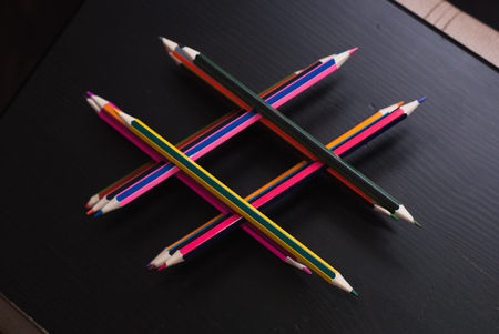 Hashtag of pencils. stacked colored pencils on the black table dark wooden surface, cost of pencilsの写真素材
