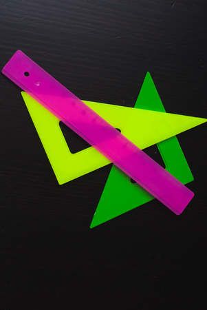 Set of accessories for measuring colored plastic, wooden table, black backgroundの写真素材