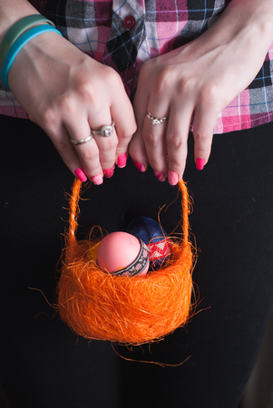Woman holding a basket of colored eggs , happy Easterの写真素材