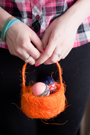 Woman holding a basket of colored eggs , happy Easterの写真素材