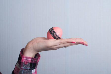 Female hand holding Easter egg, happy Easter, hand in shirtの写真素材