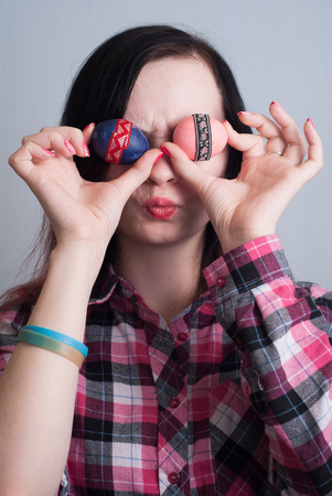 Cute girl hipster in a plaid shirt plays with Easter eggs, happy Easter, cute brunetteの写真素材