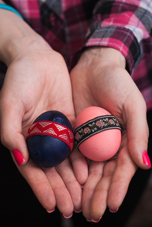 Female hand holding Easter egg, happy Easter, hand in shirtの写真素材