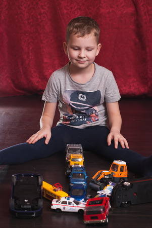 Many toy cars, little boy playing on the floor, the emergency situation on the road, the conceptual, dark hardwood floorの写真素材