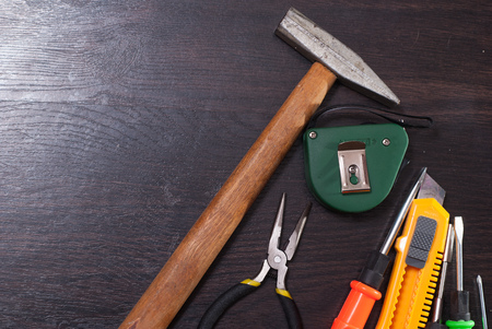 Building tools on wooden background, repair kit, bright screwdrivers, hammer, utility knife, tape measure on wooden background, concept labor dayの写真素材