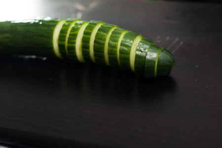Green cucumber, sliced on a black Board, fresh vegetables, healthy eating conceptの写真素材