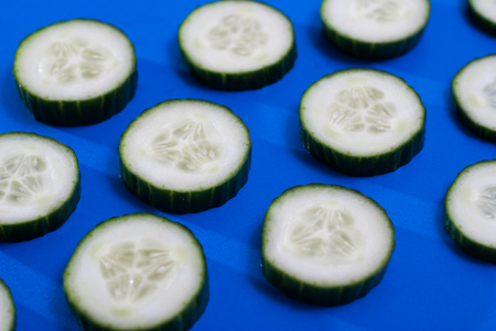 The pattern of cucumber on blue background, sliced cucumber on a full frame,の写真素材