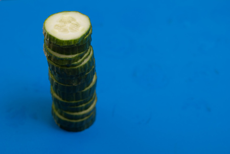 Sliced cucumber on blue background, concept of healthy nutrition,の写真素材