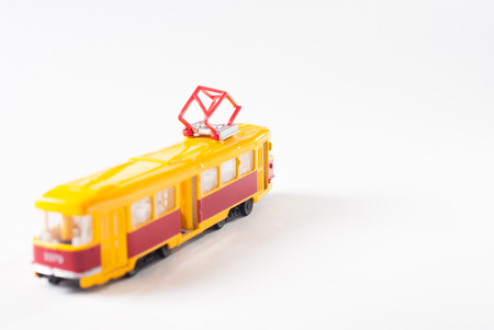 Toy tram in yellow on white background, public transport,の写真素材