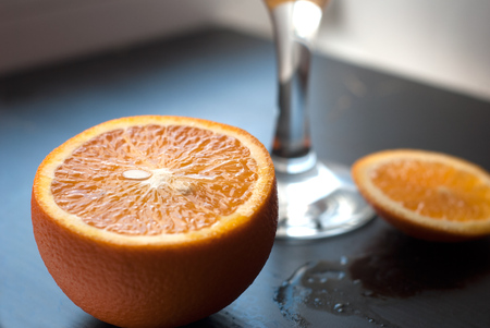 Glass on a black wooden background, closeup, composition of sliced orangesの写真素材