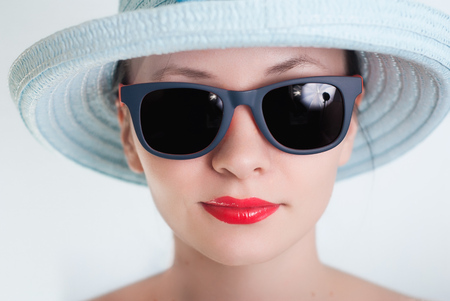 Beautiful girl in a blue hat and sunglasses,の写真素材