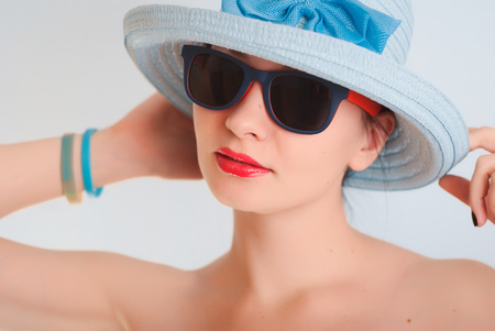 Beautiful girl in a blue hat and sunglasses,の写真素材