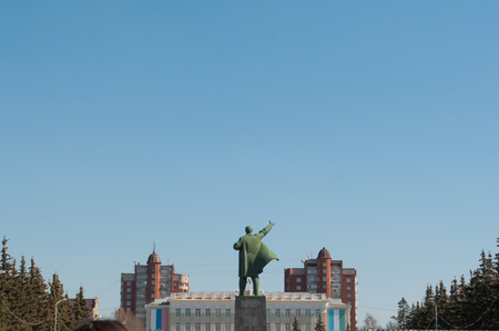 the monument to Lenin in the clear blue sky on the background of office buildings,の写真素材