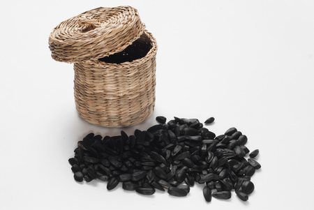 sunflower seeds in a wicker basket with lid on white background,の写真素材